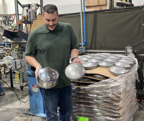 RealWheels plant manager Cory Polka holds a raw and finished product.