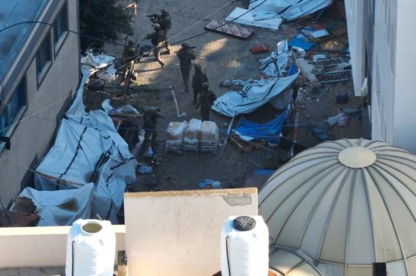 Israeli soldiers walk at the Al Shifa hospital complex