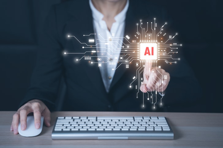 person in front of a keyboard with their finger on a floating AI visualization